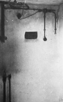 KL Majdanek – приміщення перед газовою камерою з пристроєм для вмикання бутлів з газом. Віконце у стіні дозволяло спостерігати за процесом убивства (IPN)