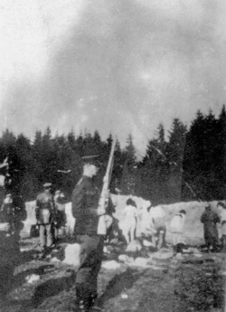 Popravy Židů v obci Ponary, v popředí litevský policista. (AIPN)