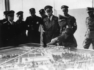 Funkcjonariusze niemieccy w trakcie wizyty w KL Dachau, na pierwszym planie przy makiecie obozu SS-Standartenführer dr Wilhelm Pfannenstiel; styczeń 1941 r. (IPN)