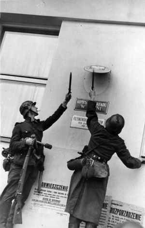 Niemieccy żołnierze usuwają godło polskie z jednego z urzędów w Gdyni; wrzesień 1939 r. (BArch)