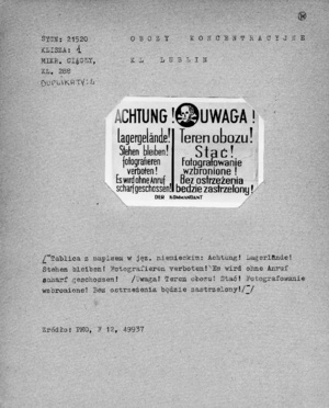 Tablica z napisem w języku niemieckimi i polskim informującym o zakazie fotografowania pod groźbą zastrzelenia. Tablice o takiej treści były umieszczane na ogrodzeniach obozów koncentracyjnych.